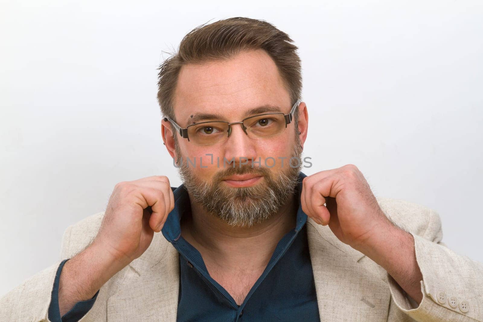 Man straightens his shirt collar - on a light background