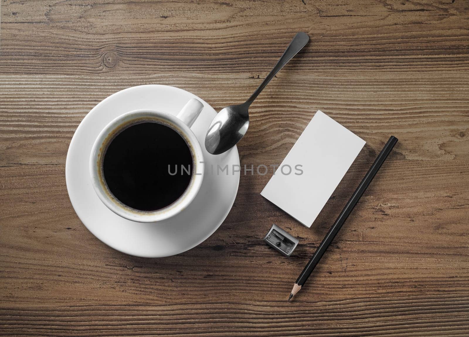 Coffee cup, bank business cards, pencil and eraser on wood table background. Top view.