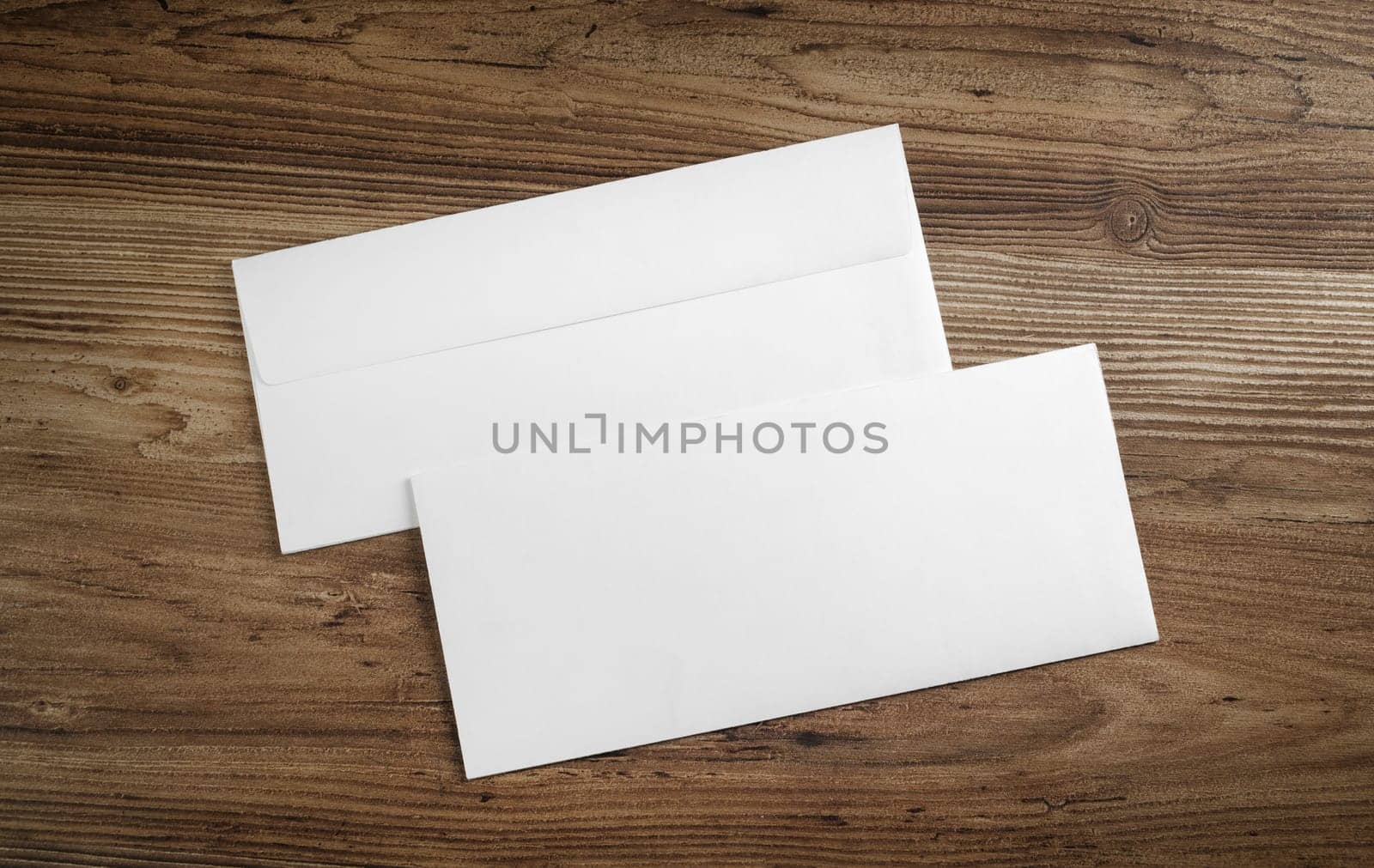 Blank paper envelopes on wooden table background. Front and back side. Template for your design. Top view.