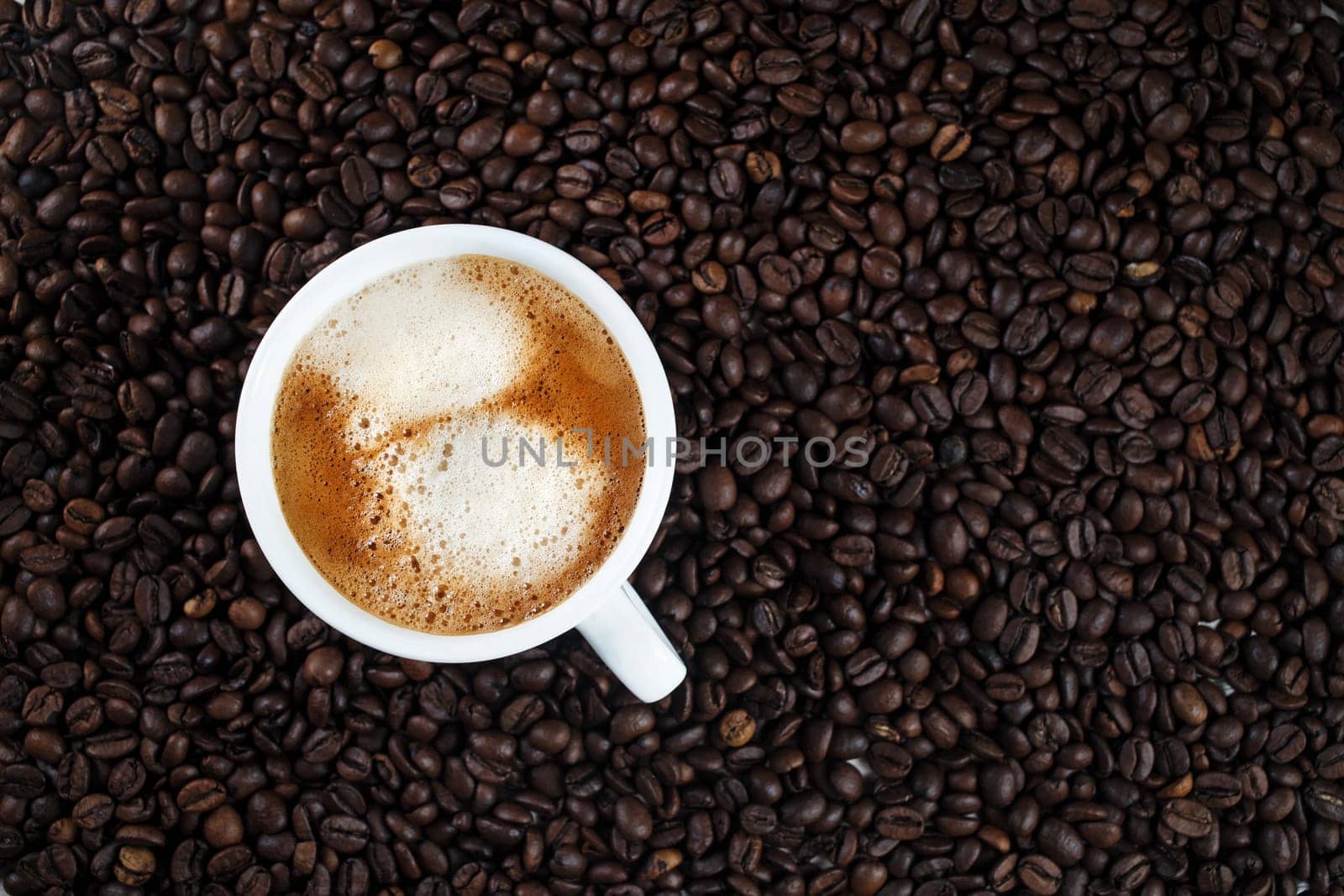 Hot delicious coffee. Espresso cup on coffee beans background.