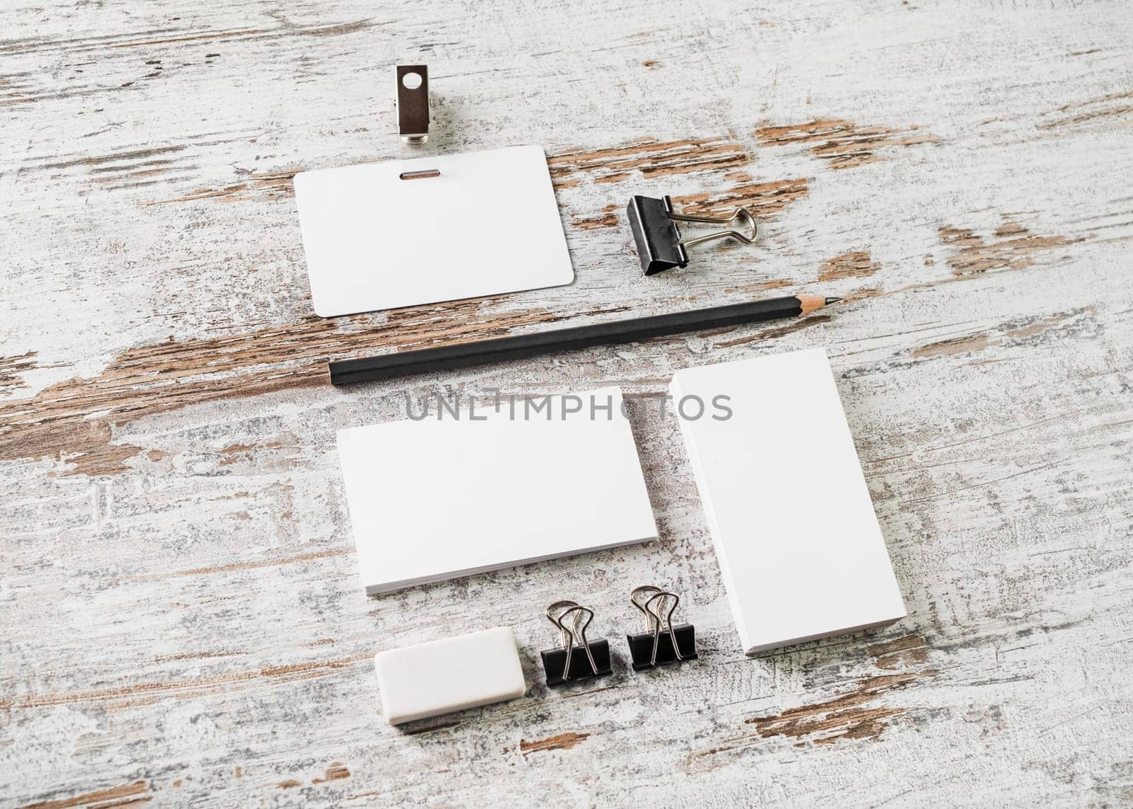 Blank branding template on vintage wooden table background. Bank business cards, pencil, eraser, badge and sharpener. Mock-up for your design. Responsive design mockup.