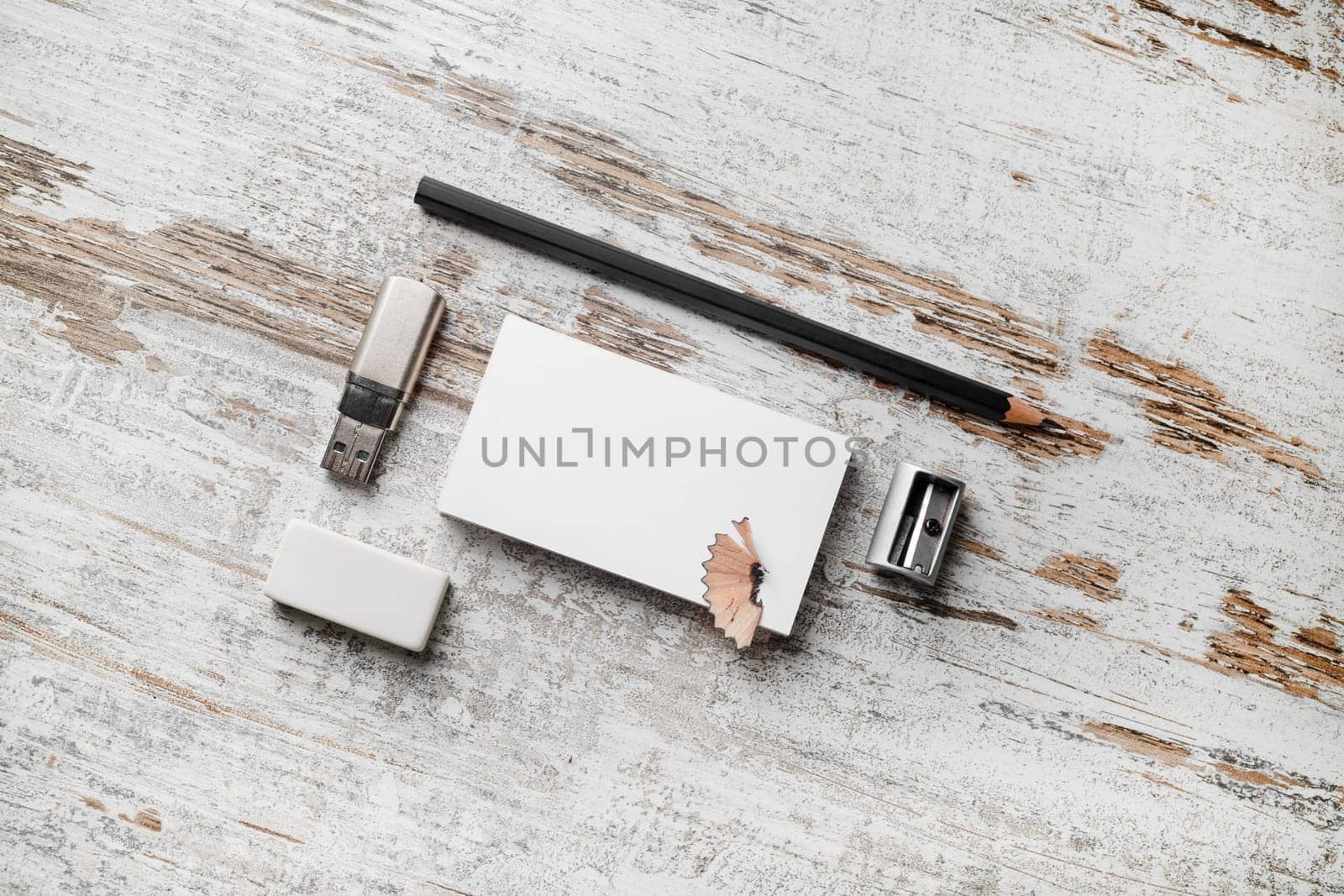Photo of blank business cards, pencil, eraser, flash drive and sharpener on vintage wooden table background. Responsive design mockup. Mock-up for branding identity.