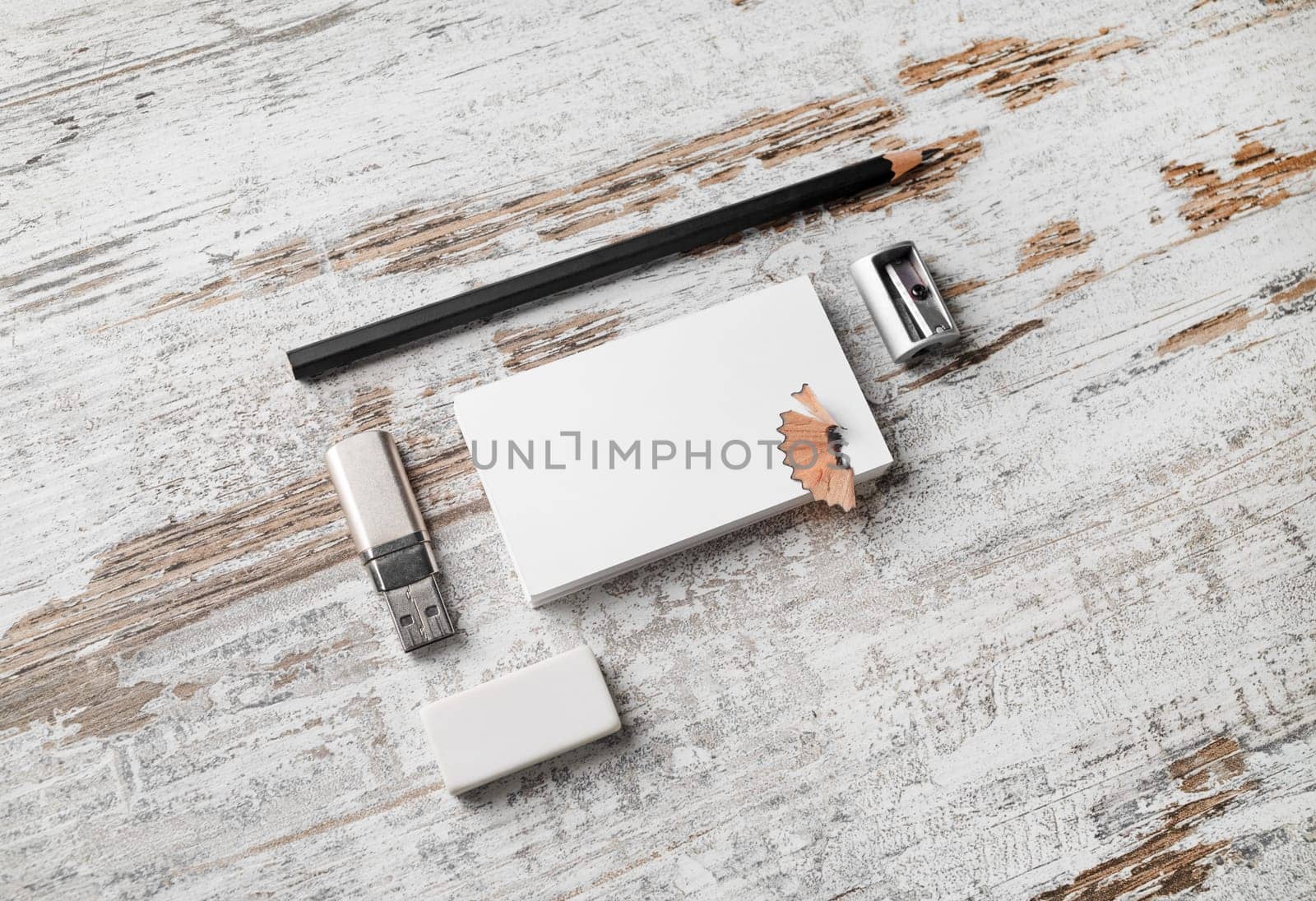 Blank paperwork template for designers. Responsive design mockup. Bank business cards, pencil, eraser, flash drive and sharpener on vintage wood table background.