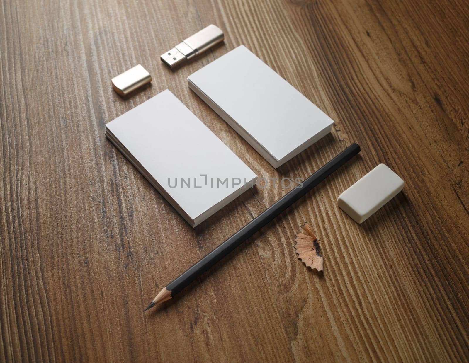 Bank business cards, pencil, eraser and flash drive. Blank paperwork template your design. Responsive design mock up on wooden background.