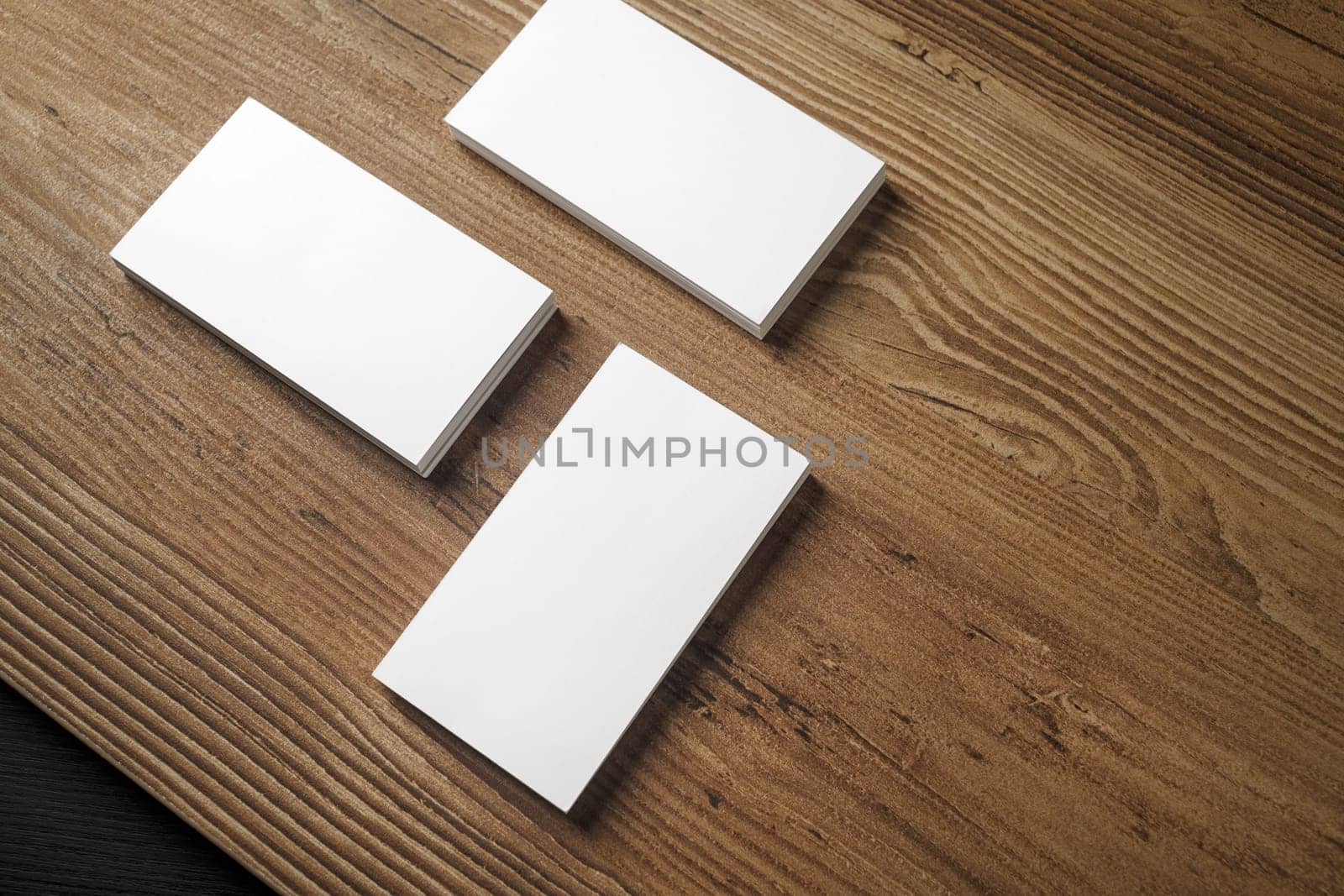 Piles of blank business cards on wood table background. Blank stationery. Mock up for branding identity for placing your design. Top view.