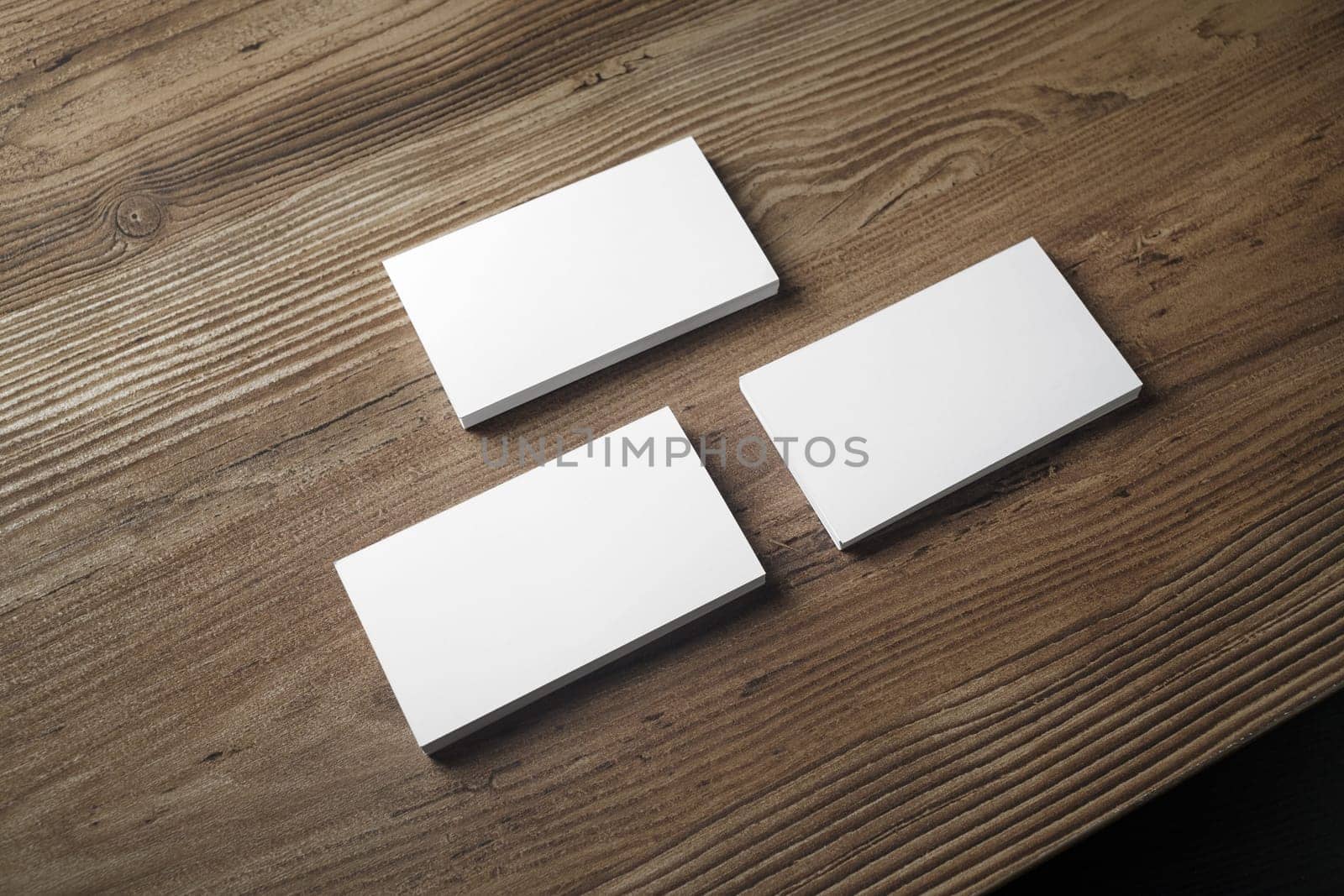 Three stacks of blank business cards on wooden table background. Mock up for branding identity. Blank template for your design.