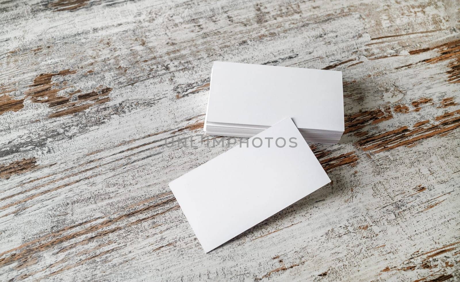 Photo of blank business cards on old wooden table background. Presentation template for designers.