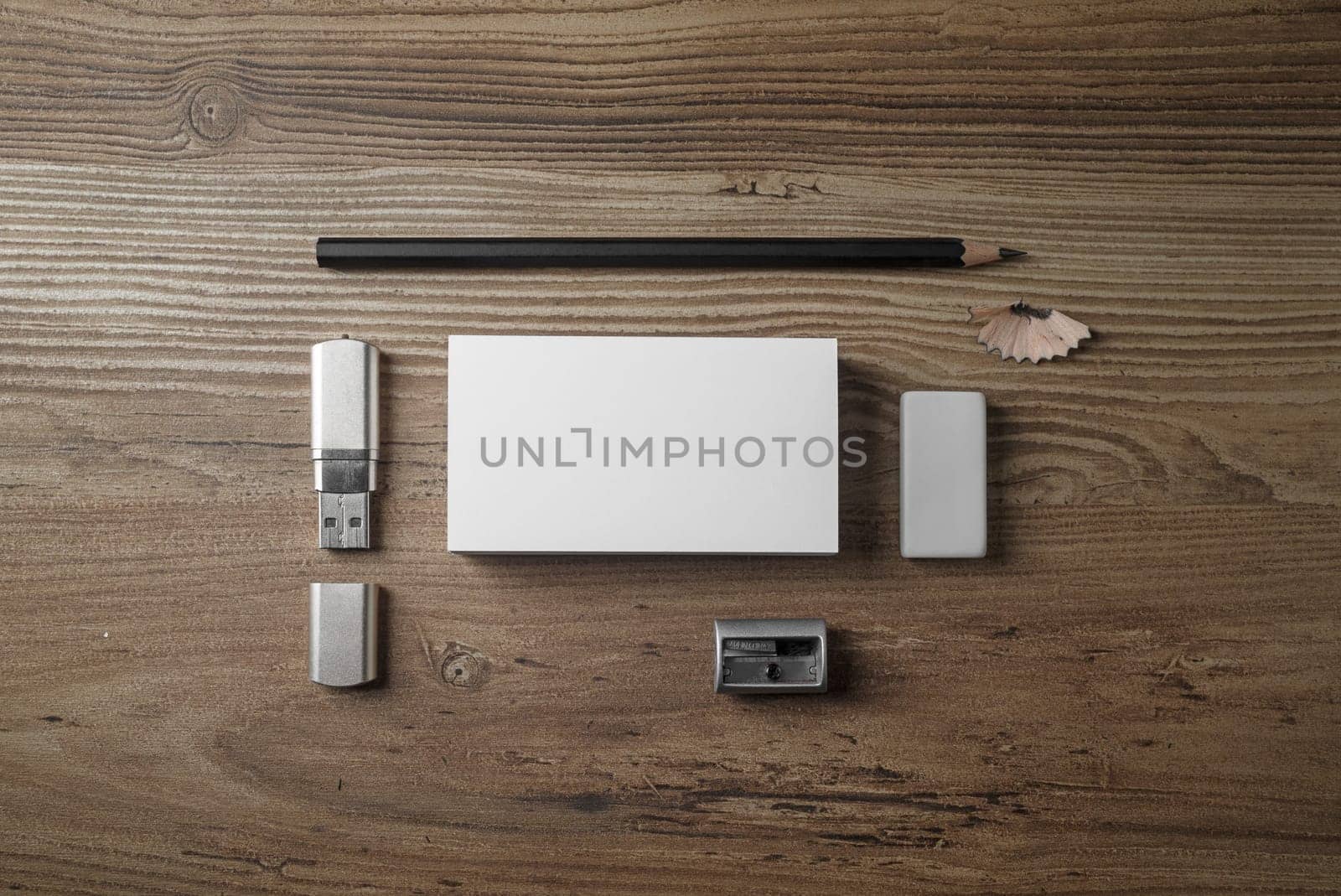 Bank business cards, pencil, eraser, flash drive and sharpener on wood table background. Photo of blank stationery set. Mock up for branding identity. Top view.