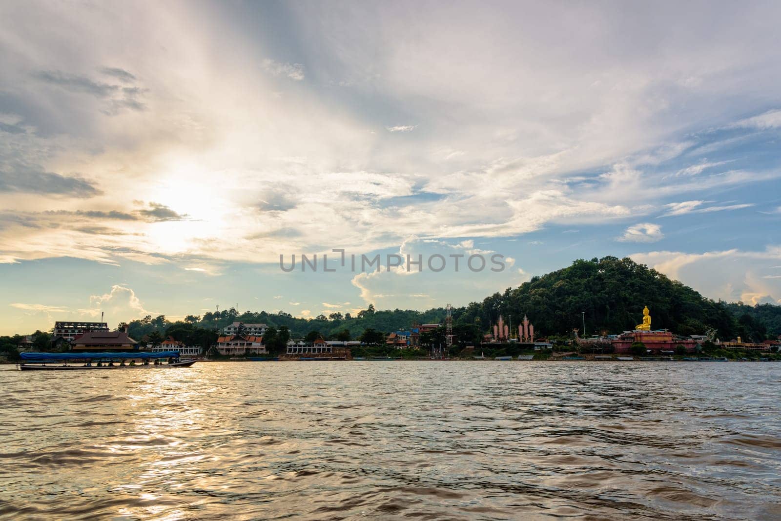 Beautiful natural landscape and tourist boat cruising the beauty of the Mekong River coast at sunset in the Golden Triangle Park (Sob Ruak) in Chiang Rai Province, Thailand