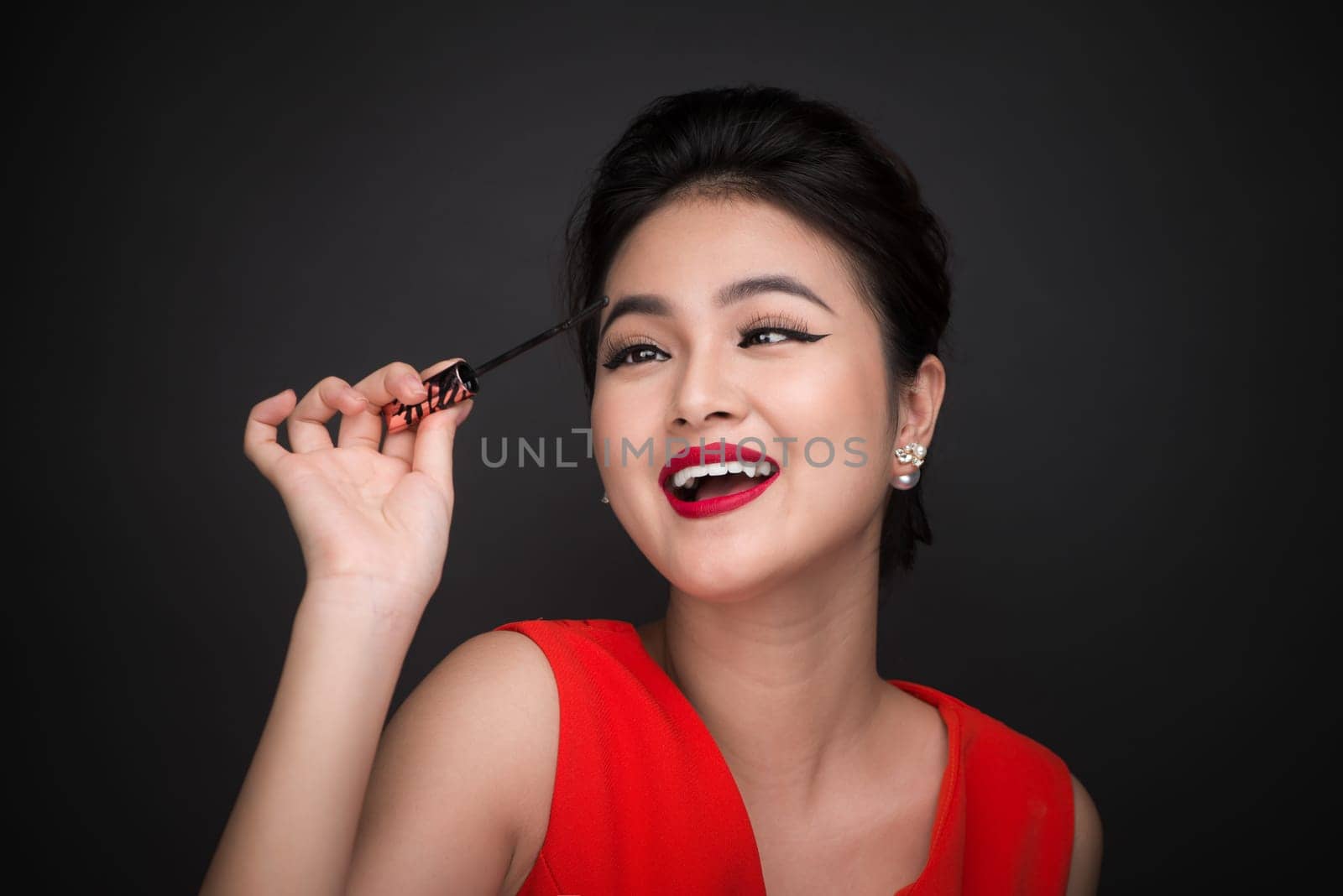 Make-up and cosmetics concept. Asian woman doing her makeup eyelashes black mascara.