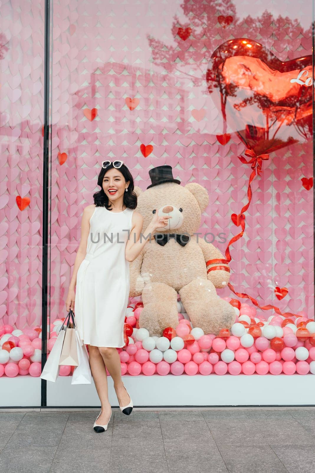 Beautiful asian girl with shopping bags standing outside the mall