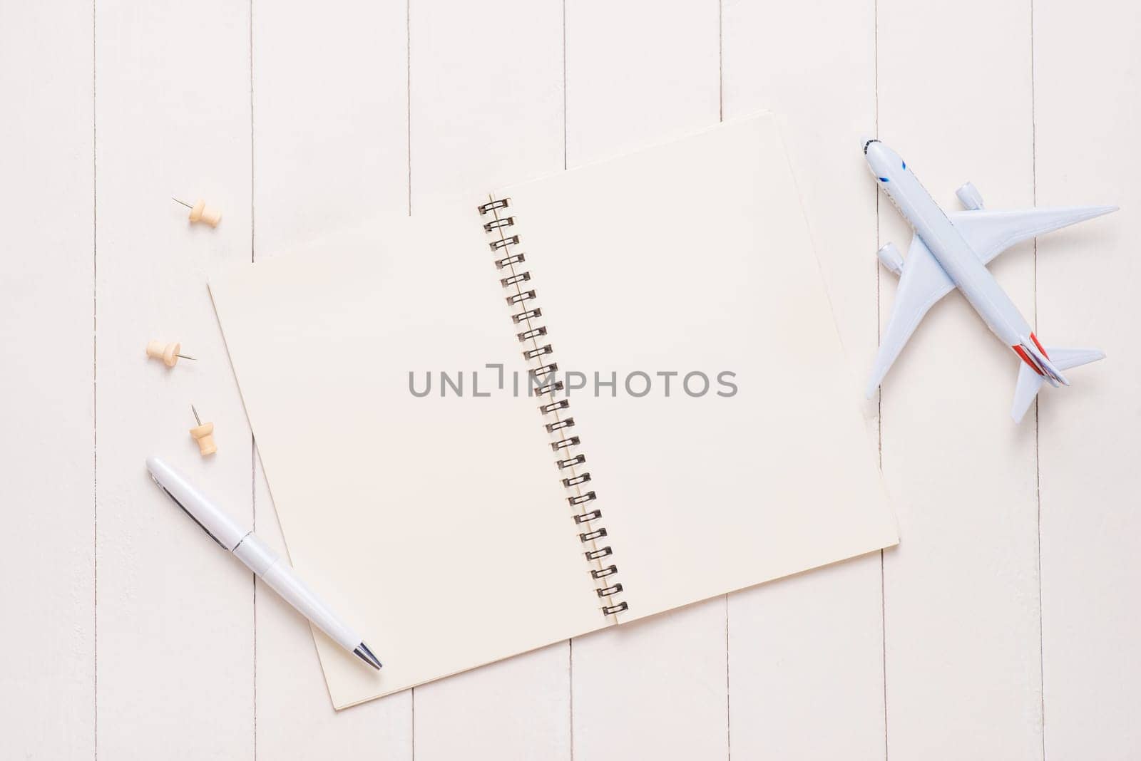 Business trip concept. Airplane and blank open notebook for your text.