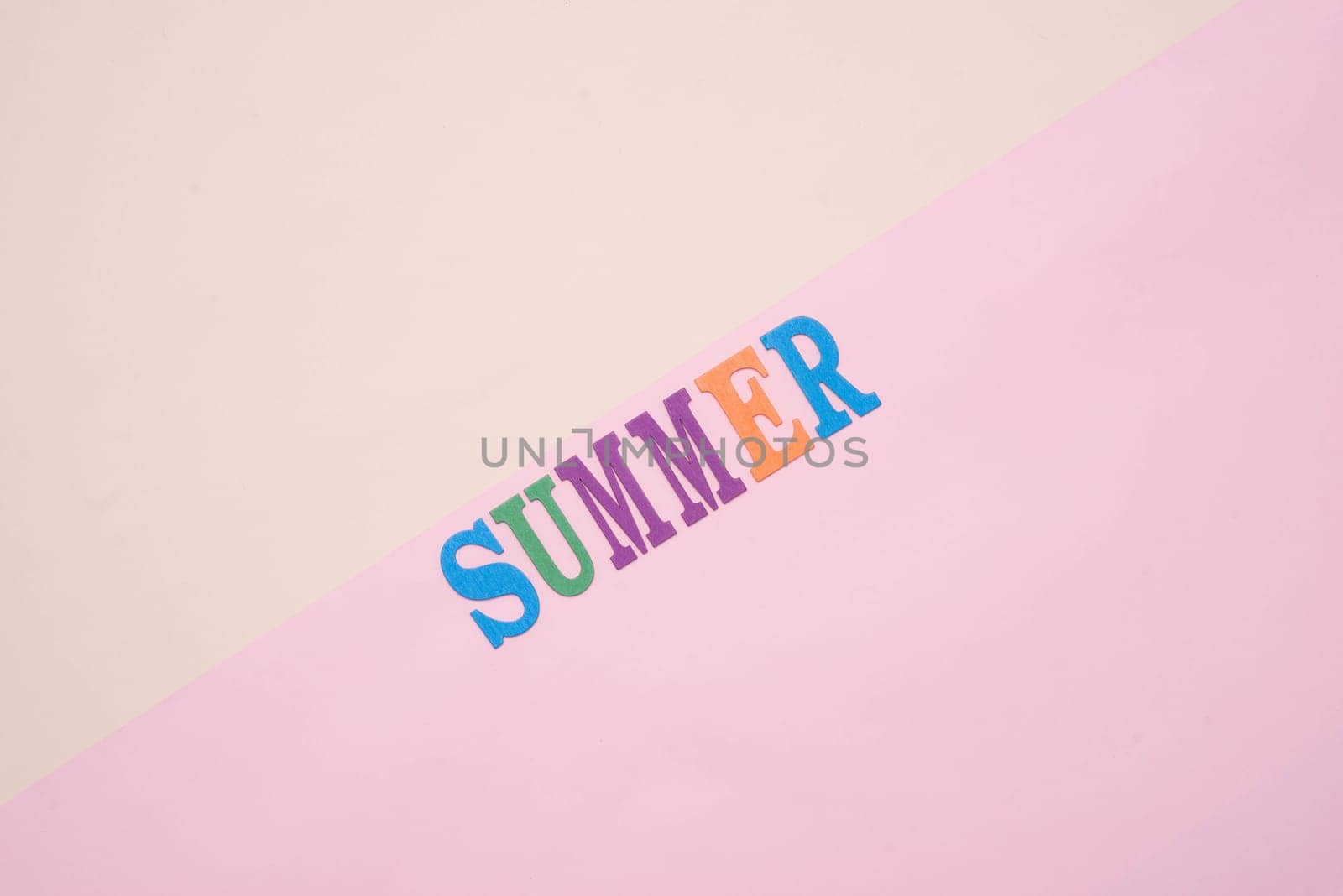 Summer fun written in colorful wooden letters on pastel color background.