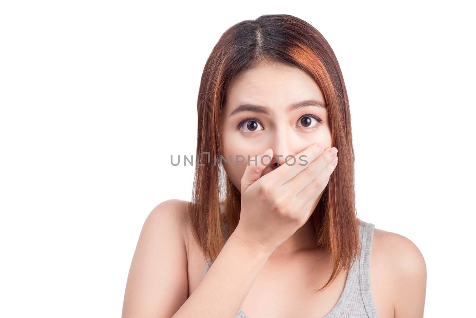 Young adult asian woman holding hand over her mouth over white background