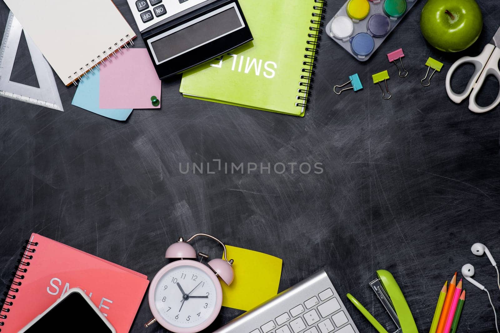 School stationery or office supplies on chalkboard background.