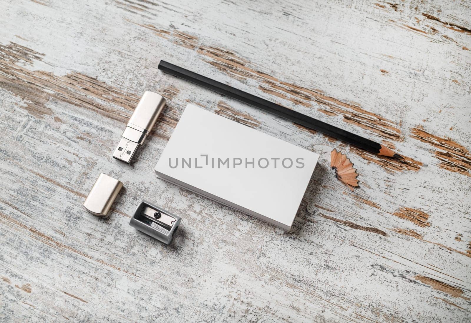 Photo of blank stationery set. Branding mockup. Bank business cards, pencil, flash drive and sharpener on vintage wood table background.
