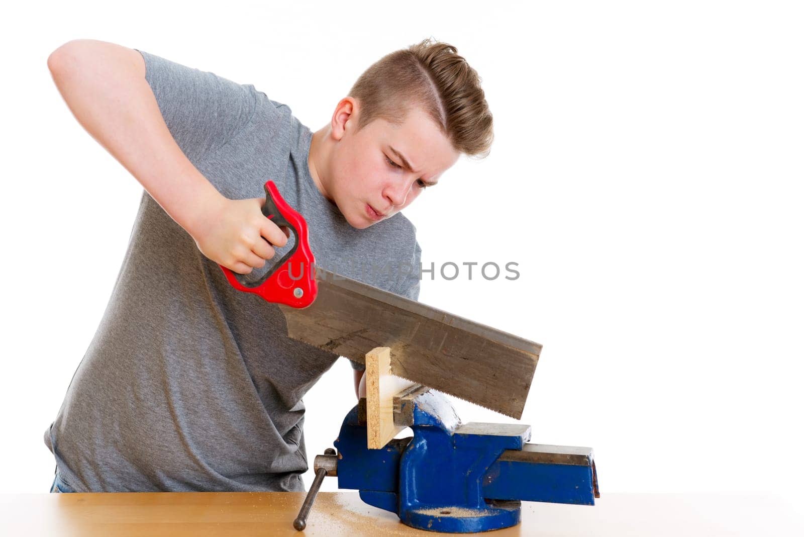 teenager in professional training using hand saw in front of white background