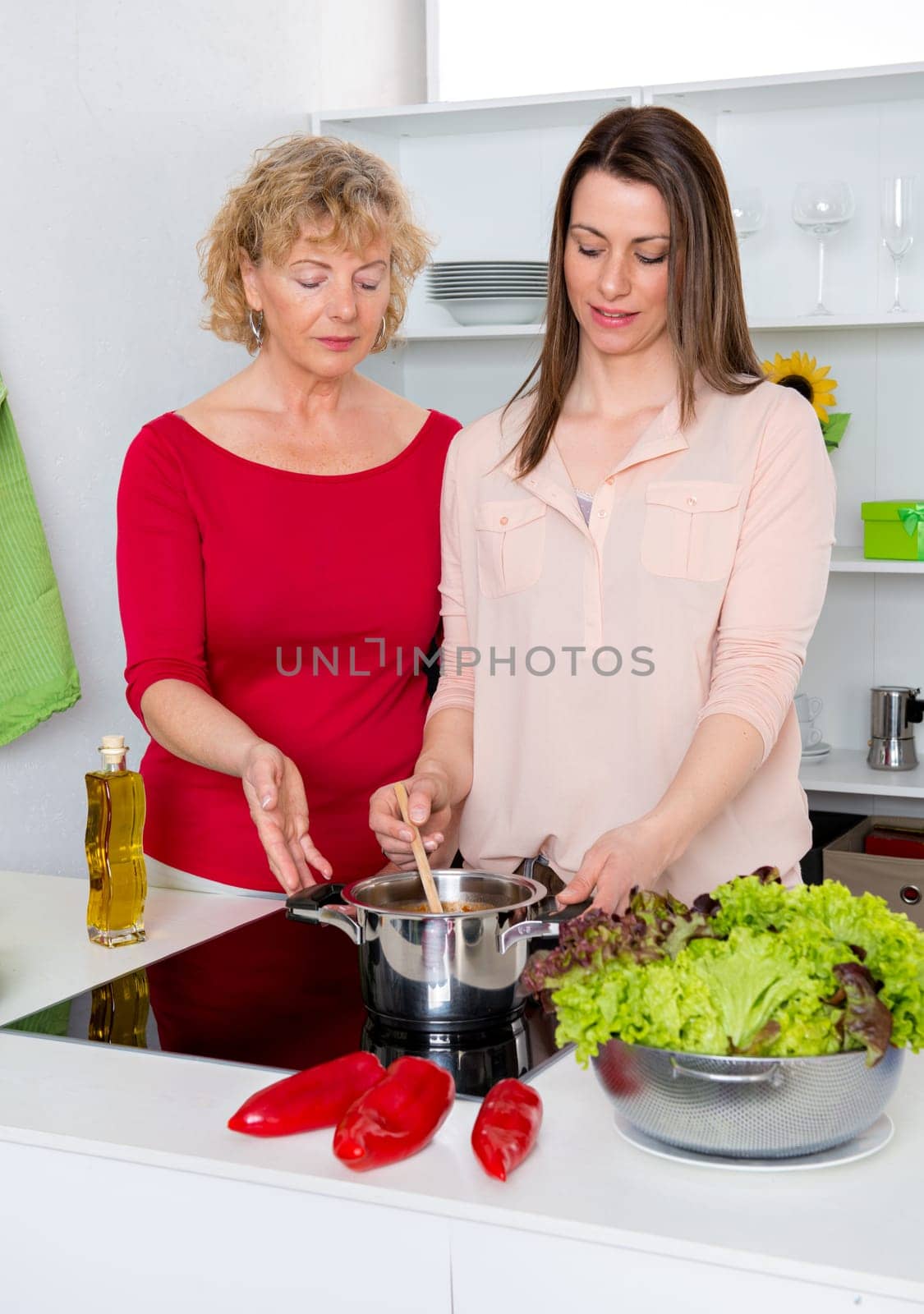 young woman and her mother cooking together in the kitchen