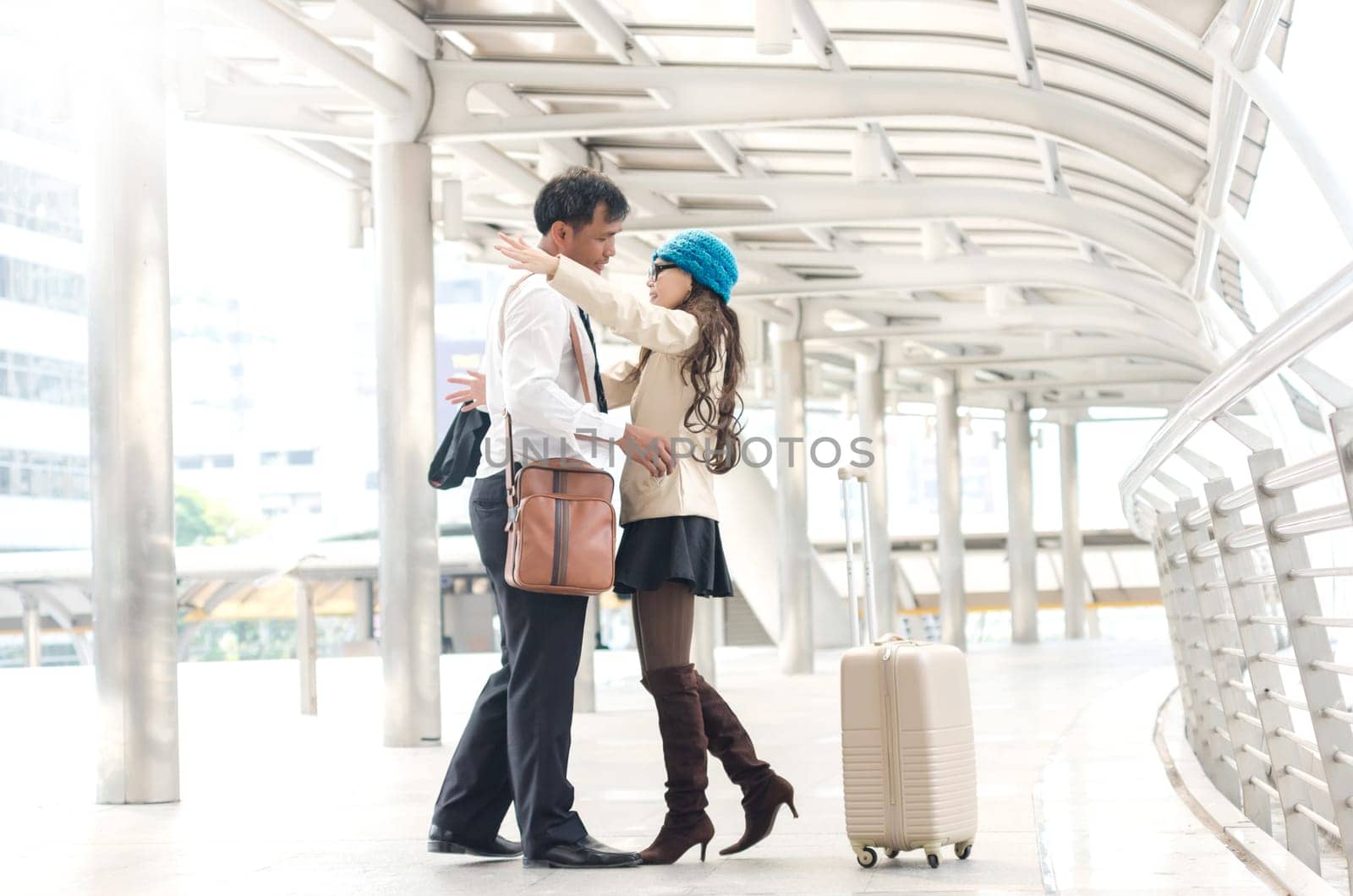 Asian lovely couple hugging at transport hubs in the metropolis.
