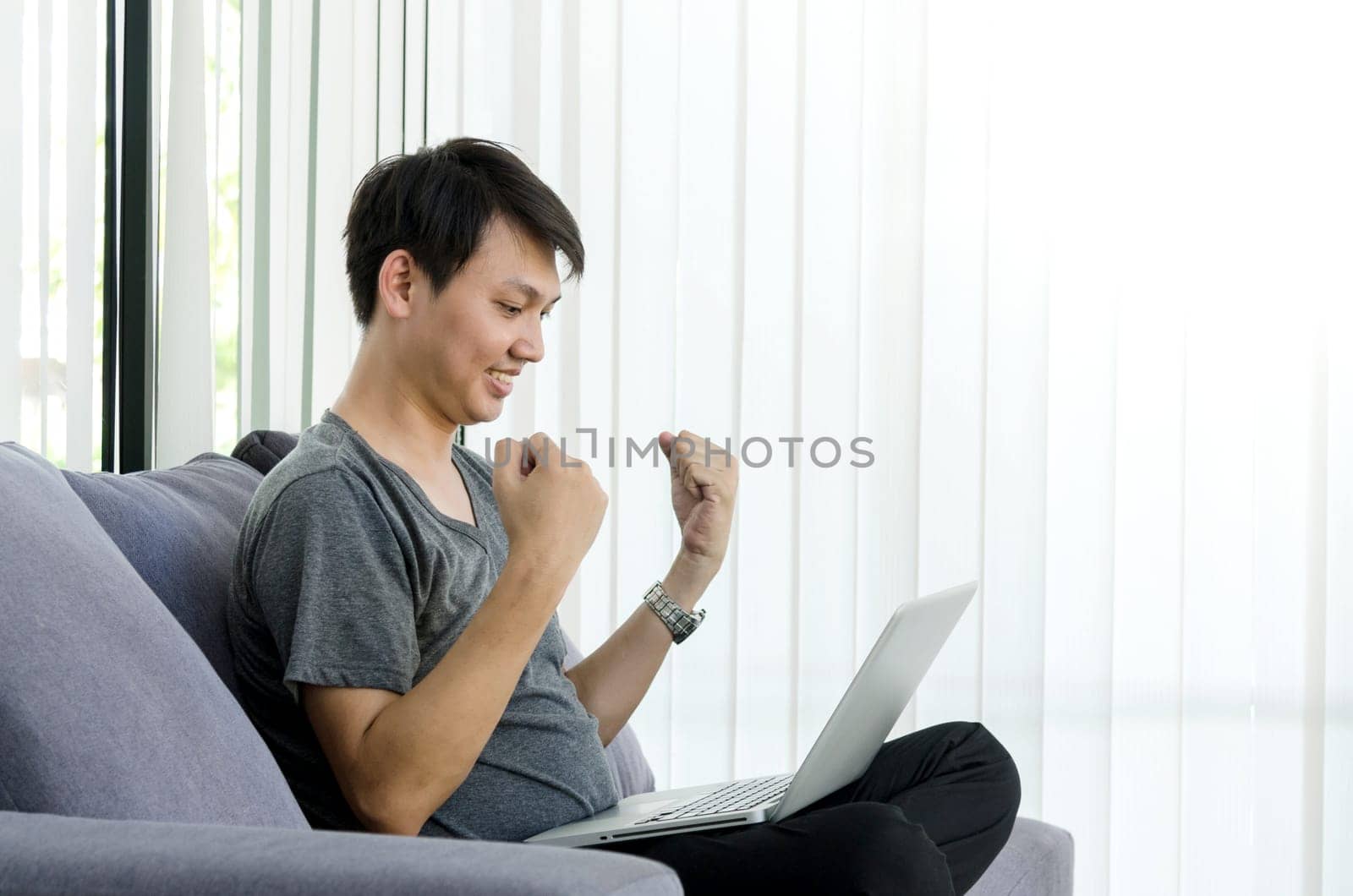 Success concept. Young asian man hands happiness moment with computer laptop.
