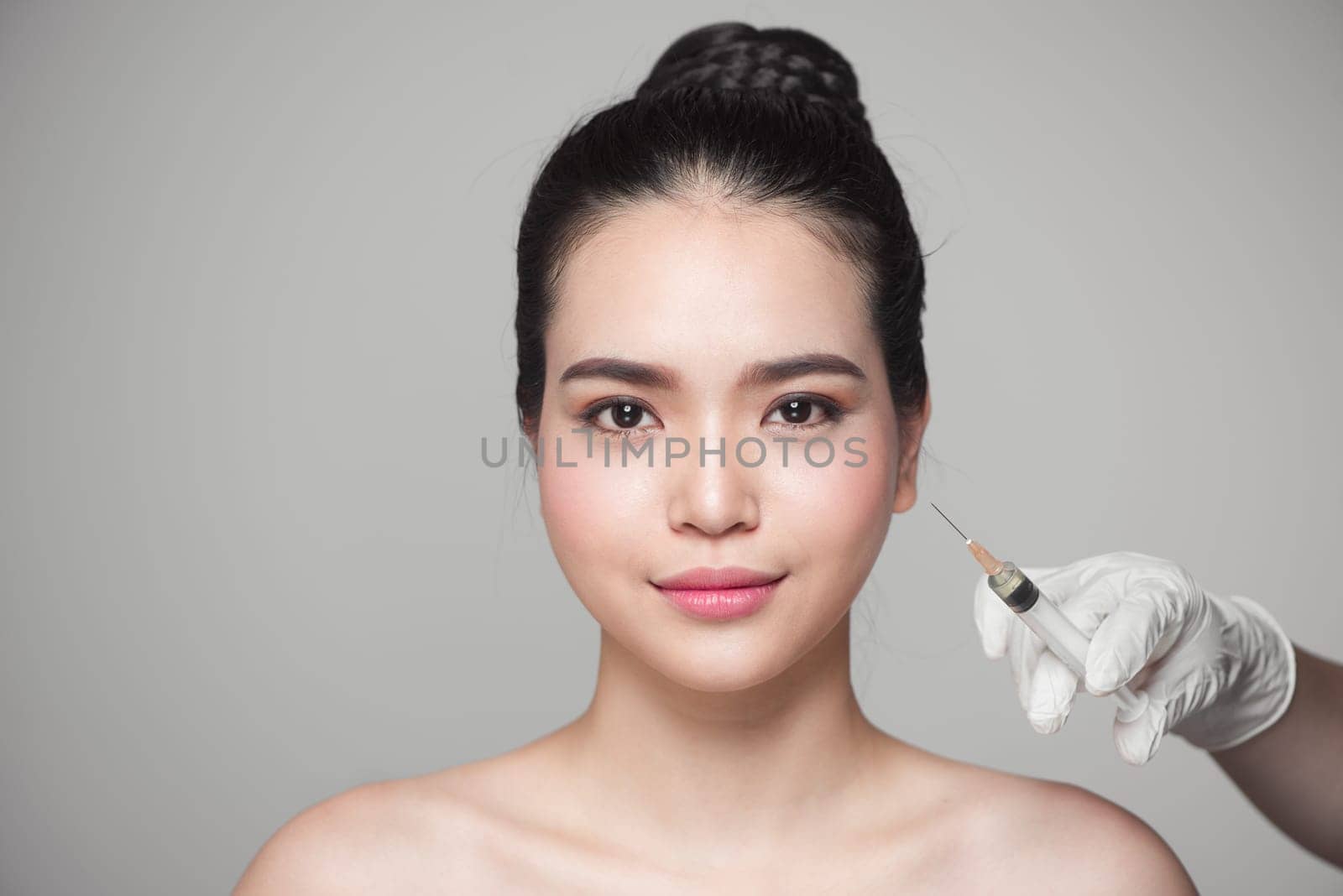 Beautiful asian woman gets beauty facial injections. Face aging injection.