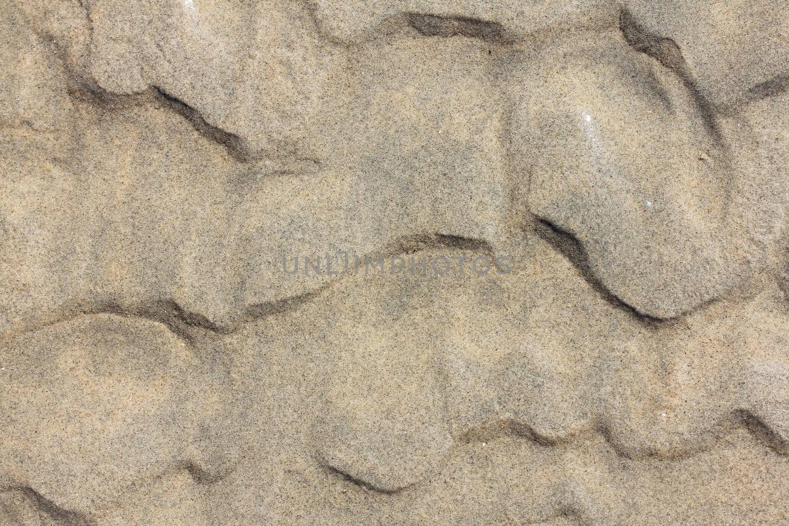 A wavy pattern in beige sand.