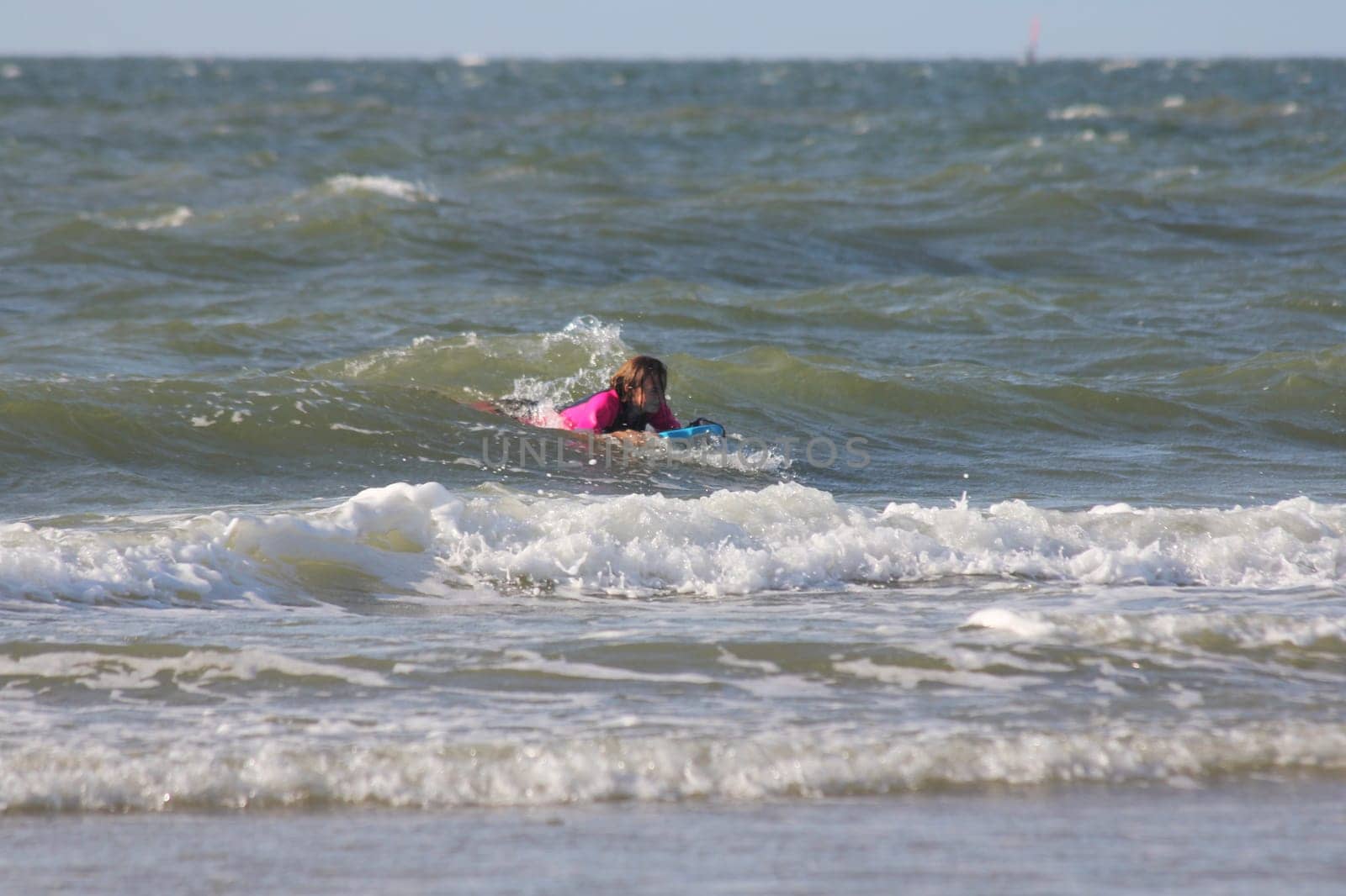 two blonde girls bathing in the sea.