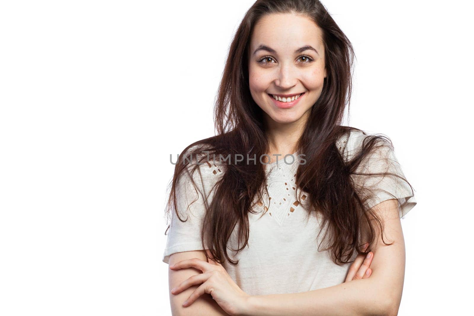 Portrait of a young smiling woman looking relaxed, confident, with her arms crossed, isolated on white