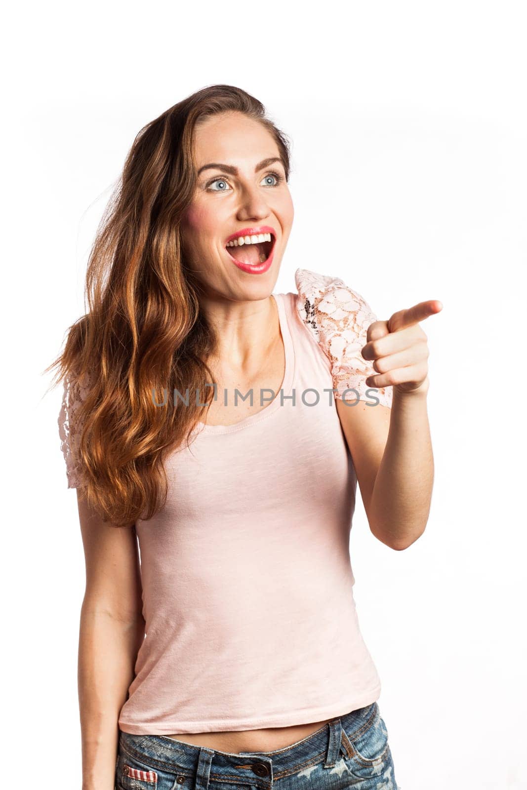 Portrait of a surprised and happy woman pointing at the copy space, isolated on white