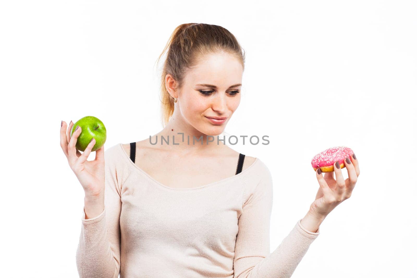 Portrait of a beautiful girl with a green apple and a donut, isolated on white