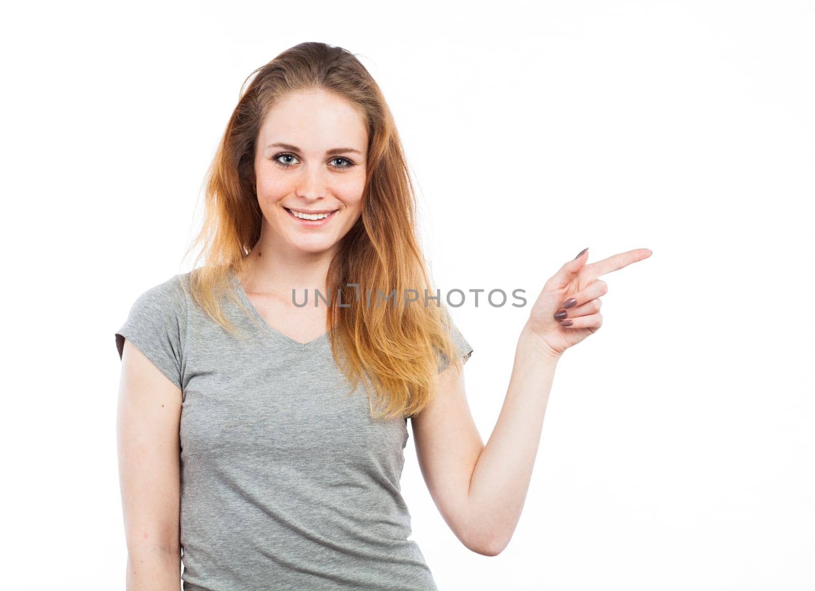 Portrait of an attractive woman pointing at the copy space, isolated on white