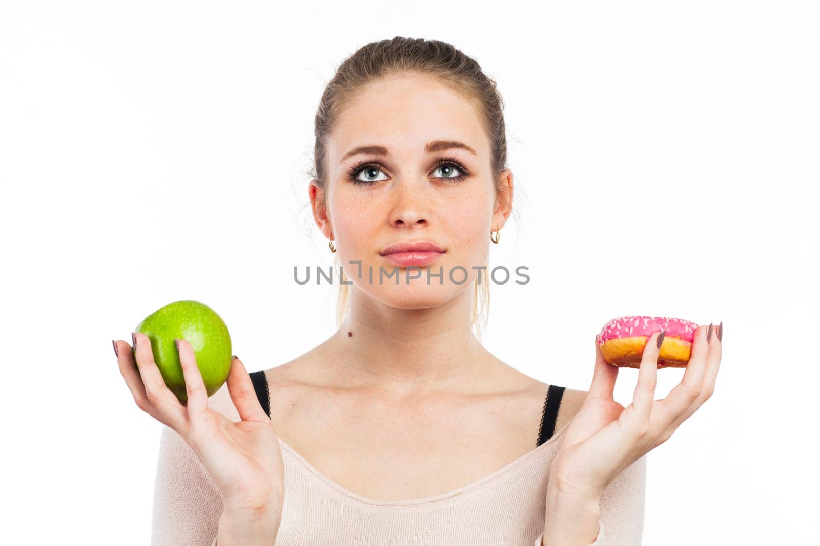Portrait of a beautiful girl with a green apple and a donut, isolated on white