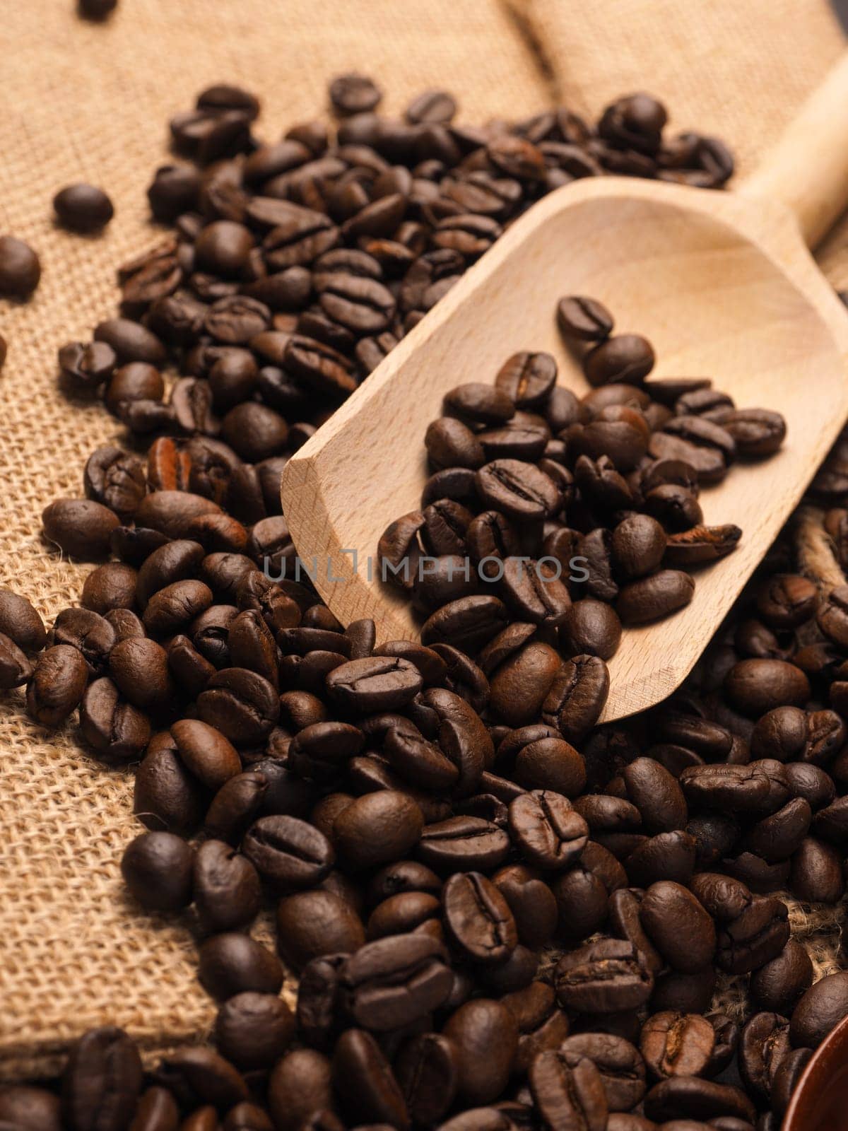 Close up of coffee beans and a wooden shovel on burlap bag