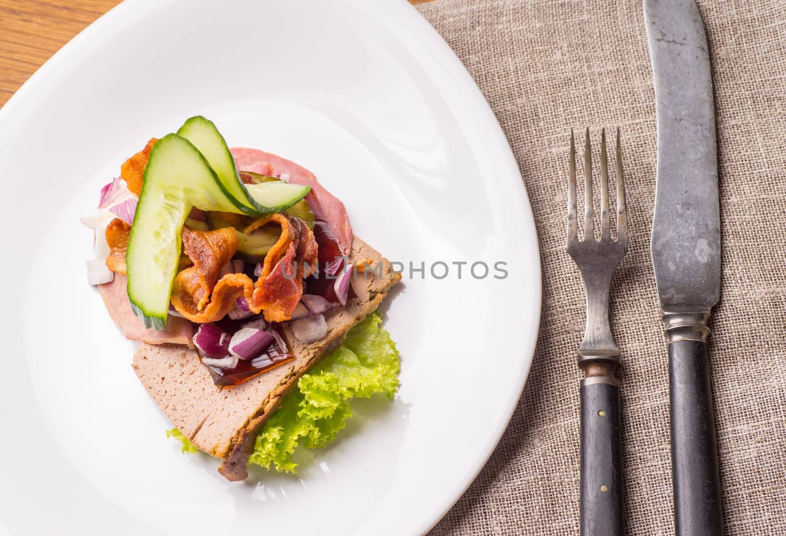 Danish specialties and national dishes, high-quality open sandwich.The very famous piece of butterbread called Veterinarian's midnight snack consisting of liverpostej, Jelly and salty beef meat, served on a plate ready for eating