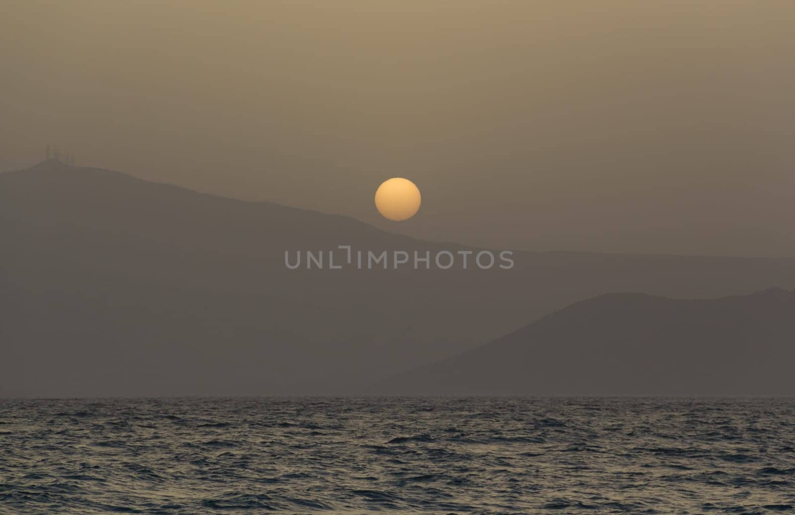 Beautiful dreamy sunset, a view through misty air from Naxos island.