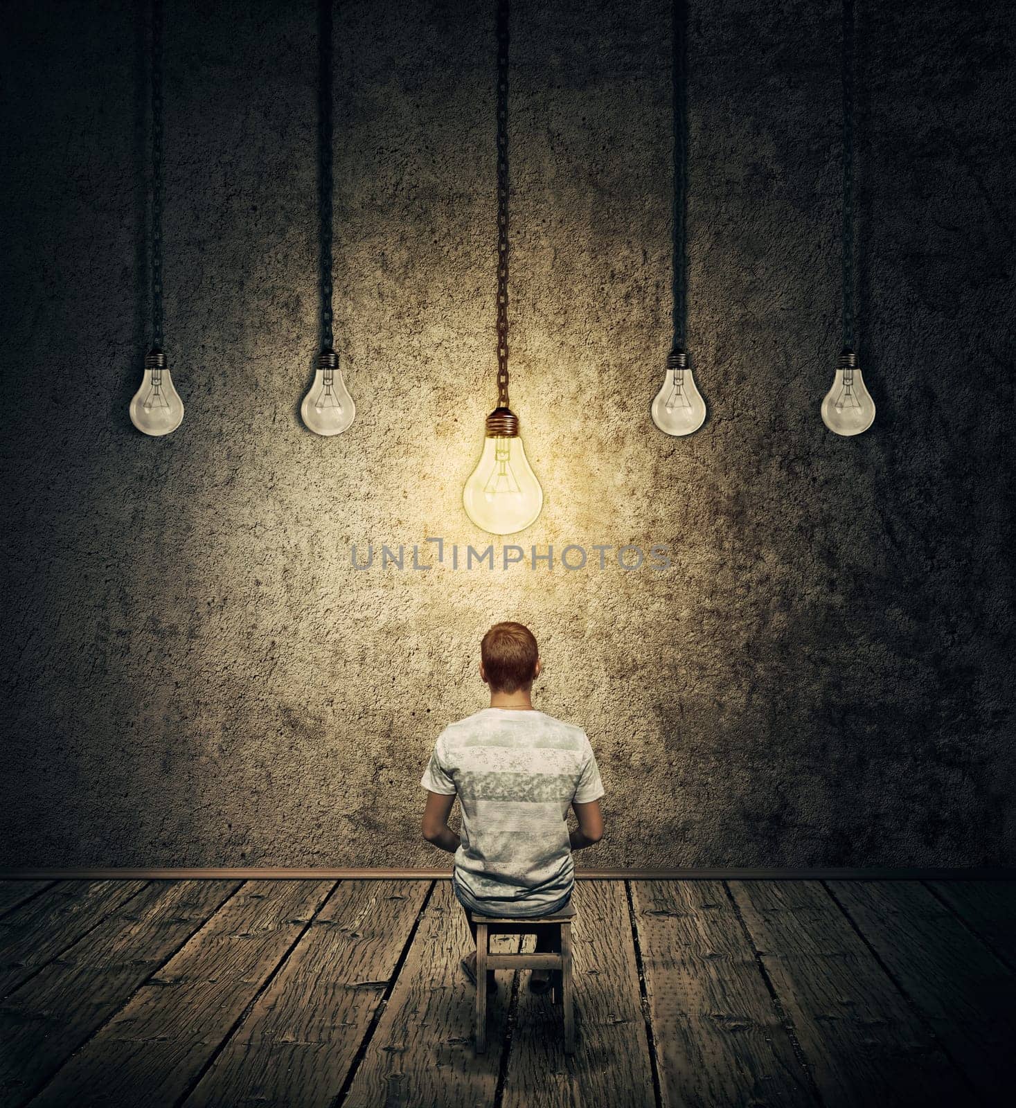 Creative idea concept with a person sitting in a dark room with suspended lightbulbs and one glowing over head. Symbolizing smart person having idea