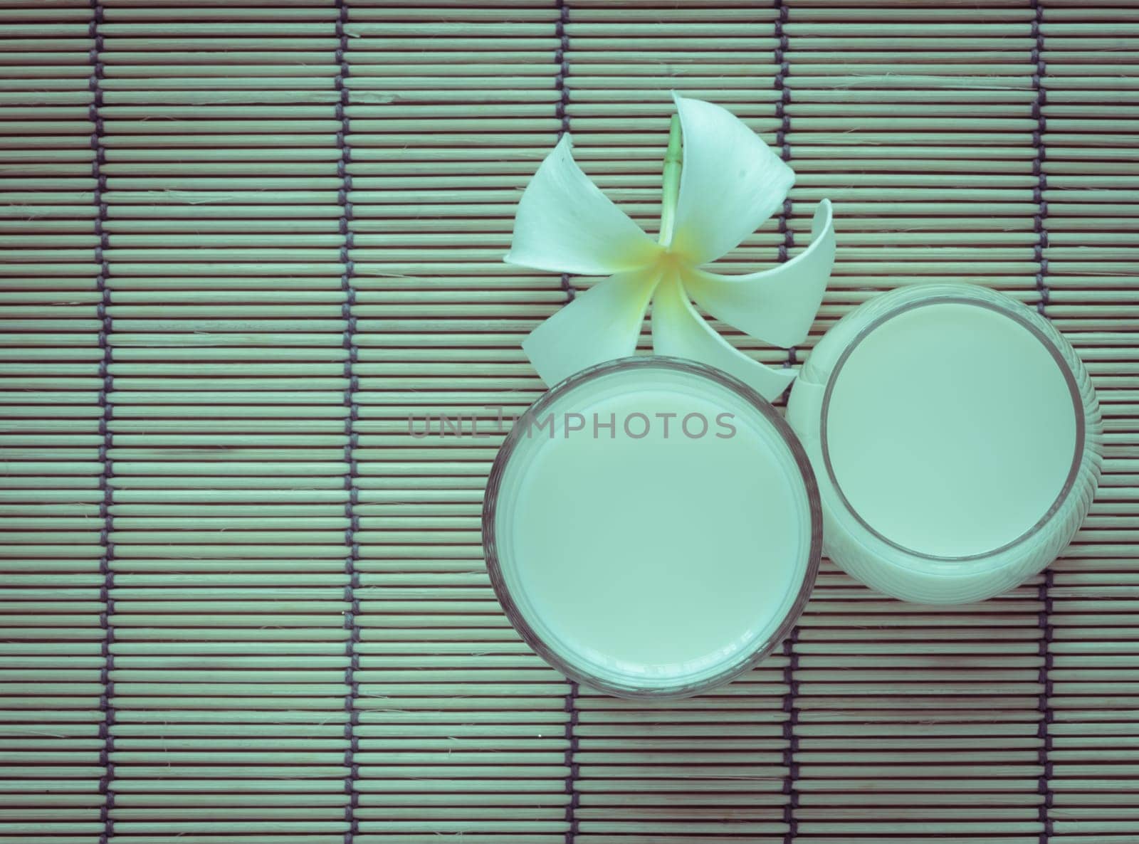 Fresh Soy milk (Soya milk) on bamboo place mat with white plumeria flower. Retro-Vintage filter effect