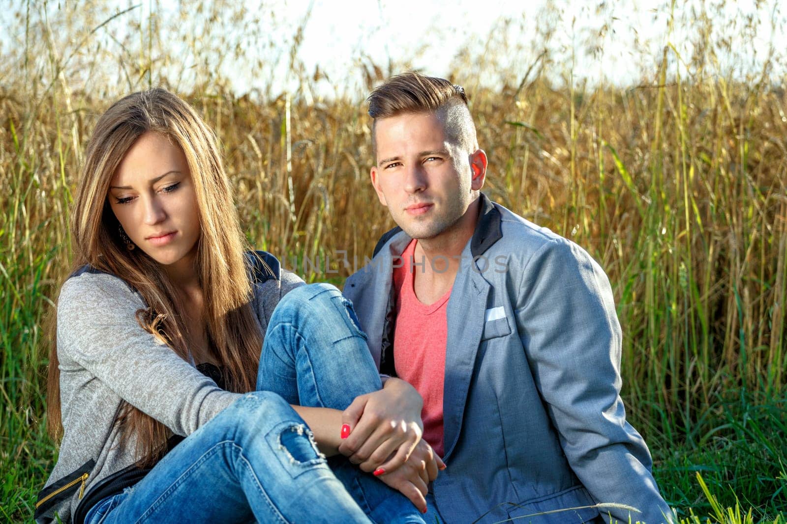 portrait of happy smiling young couple in love embracing outdoor at sunny day
