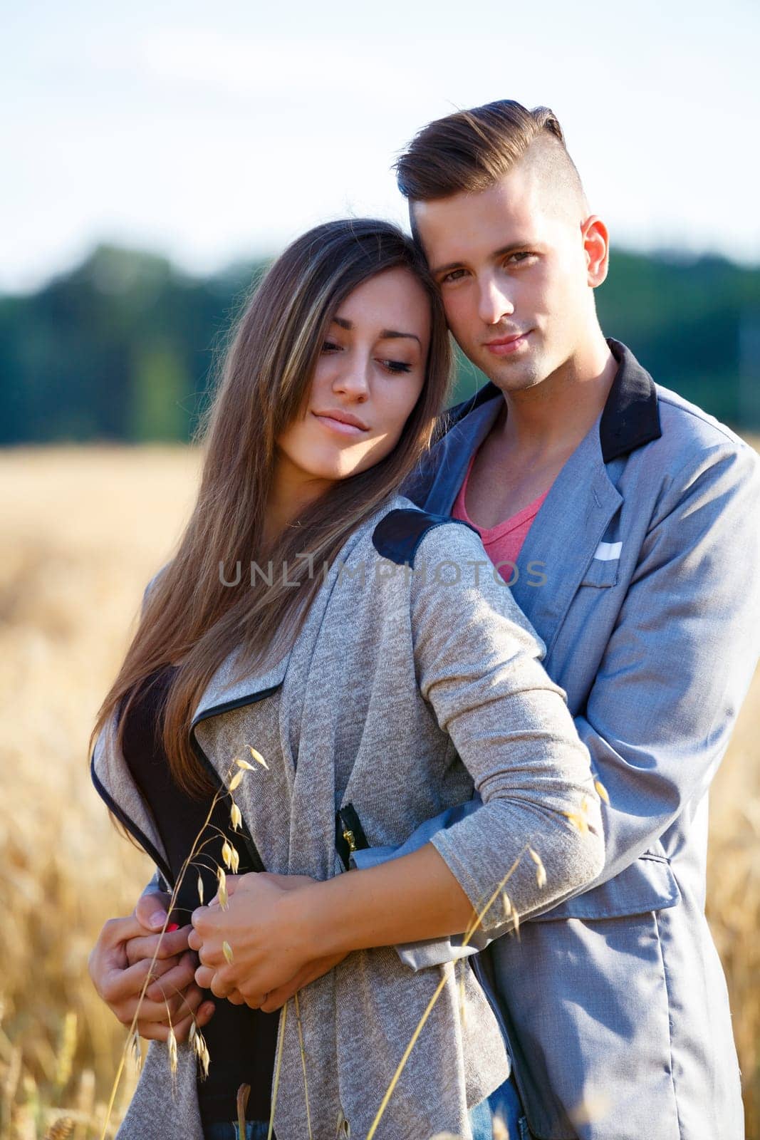 portrait of happy smiling young couple in love embracing outdoor at sunny day
