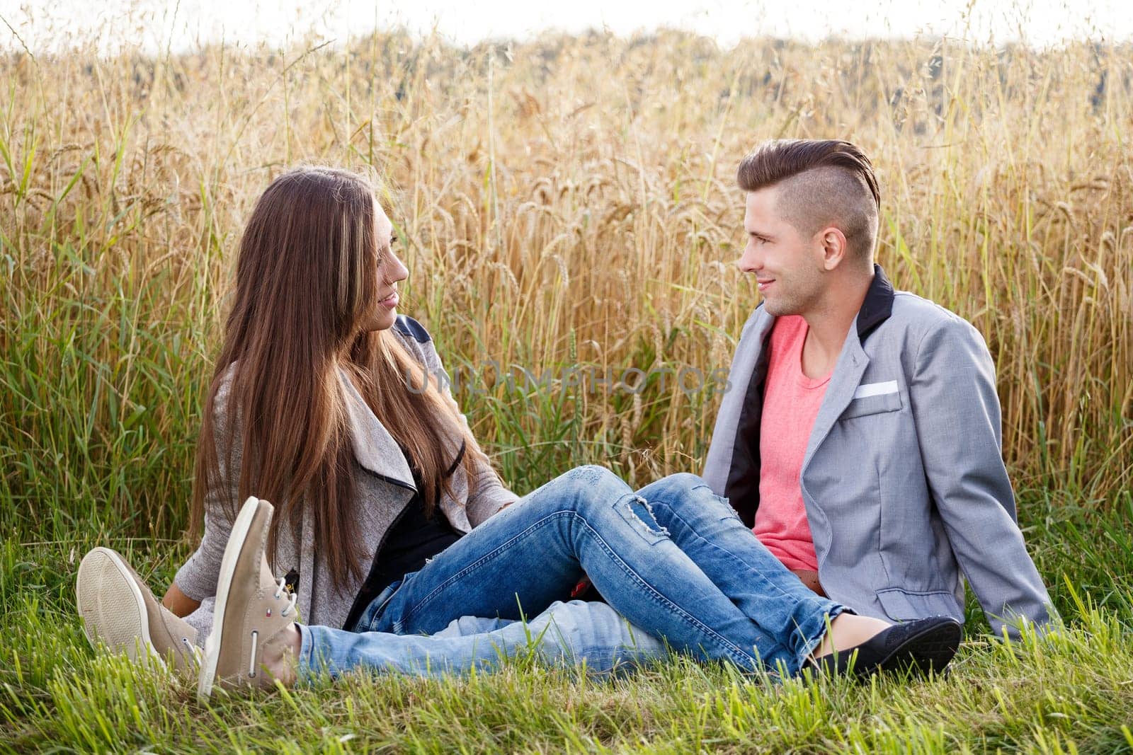 portrait of happy smiling young couple in love embracing outdoor at sunny day