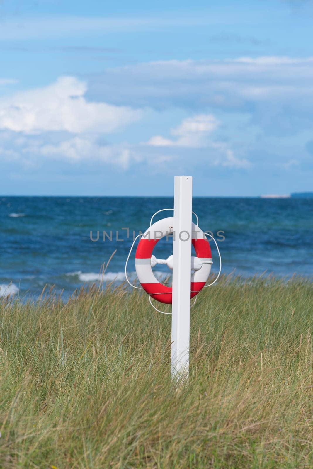 orange with white life buoy along a danish beach