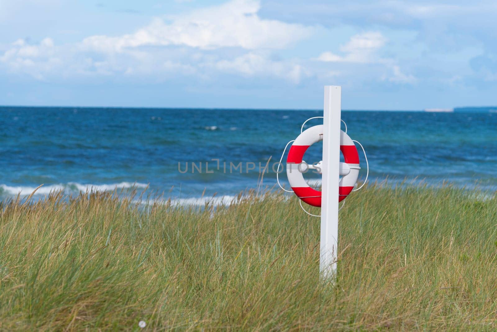 orange with white life buoy along a danish beach