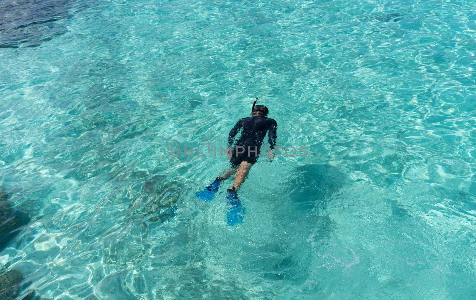 Young woman snorkeling in tropical water on vacation