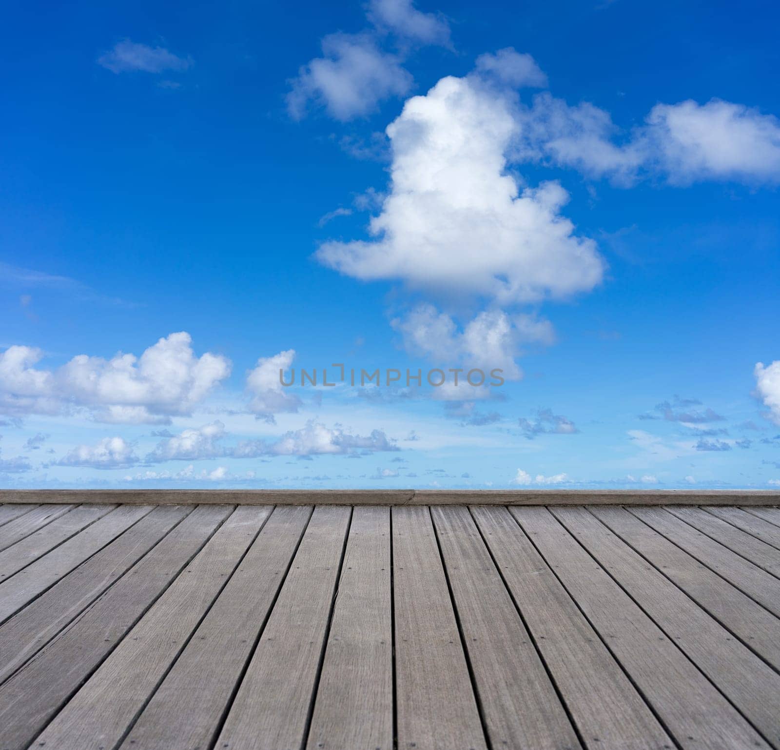 wooden floor with cloudy blue sky background