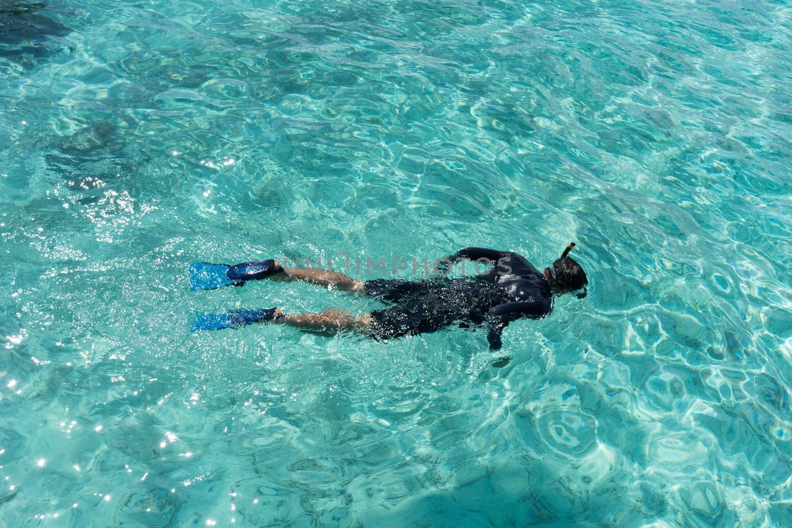 Young woman snorkeling in tropical water on vacation