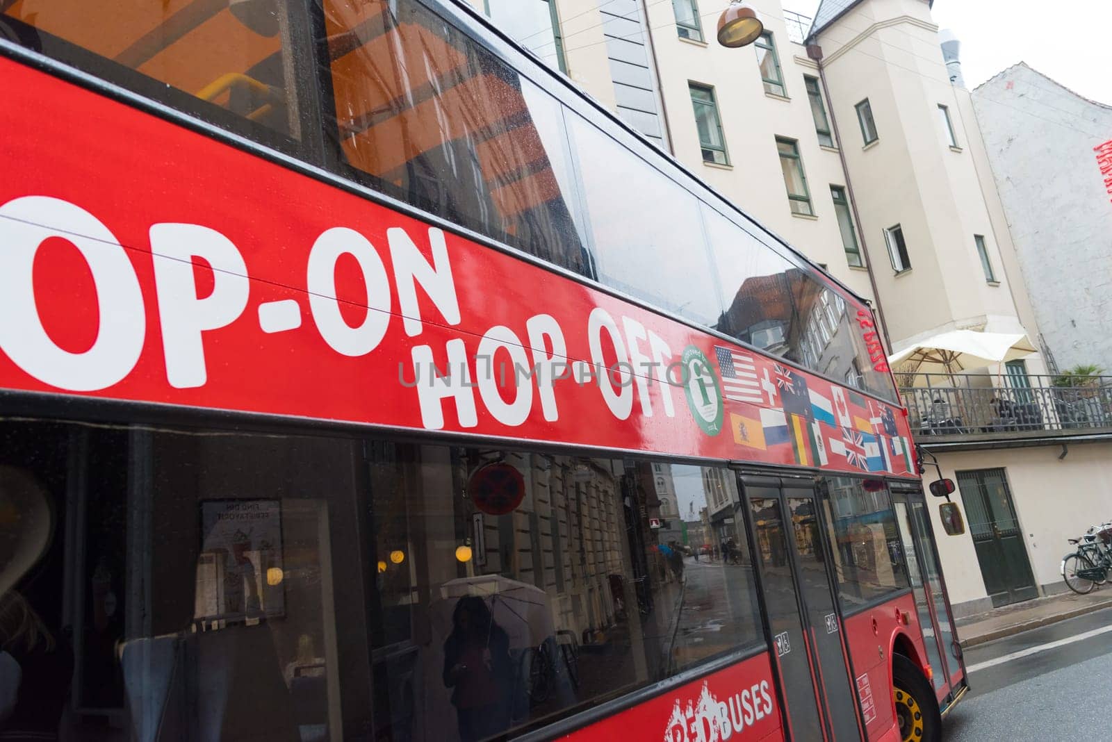 COPENHAGEN, DENMARK - AUGUST 3, 2016: Hop-on Hop off sightseeing bus passing by in the danish capital