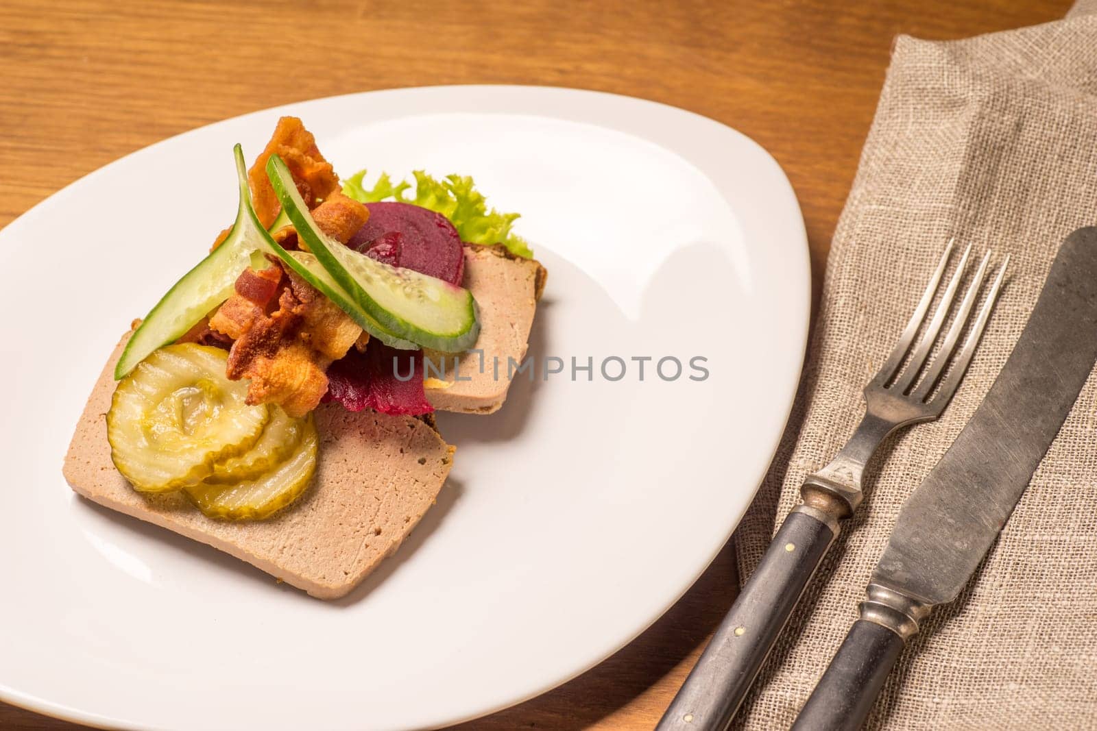 Danish specialties and national dishes, high-quality open sandwich, Liver Pate with bacon pickled cucumber, beetroot and cucumber served on a plate ready for eating