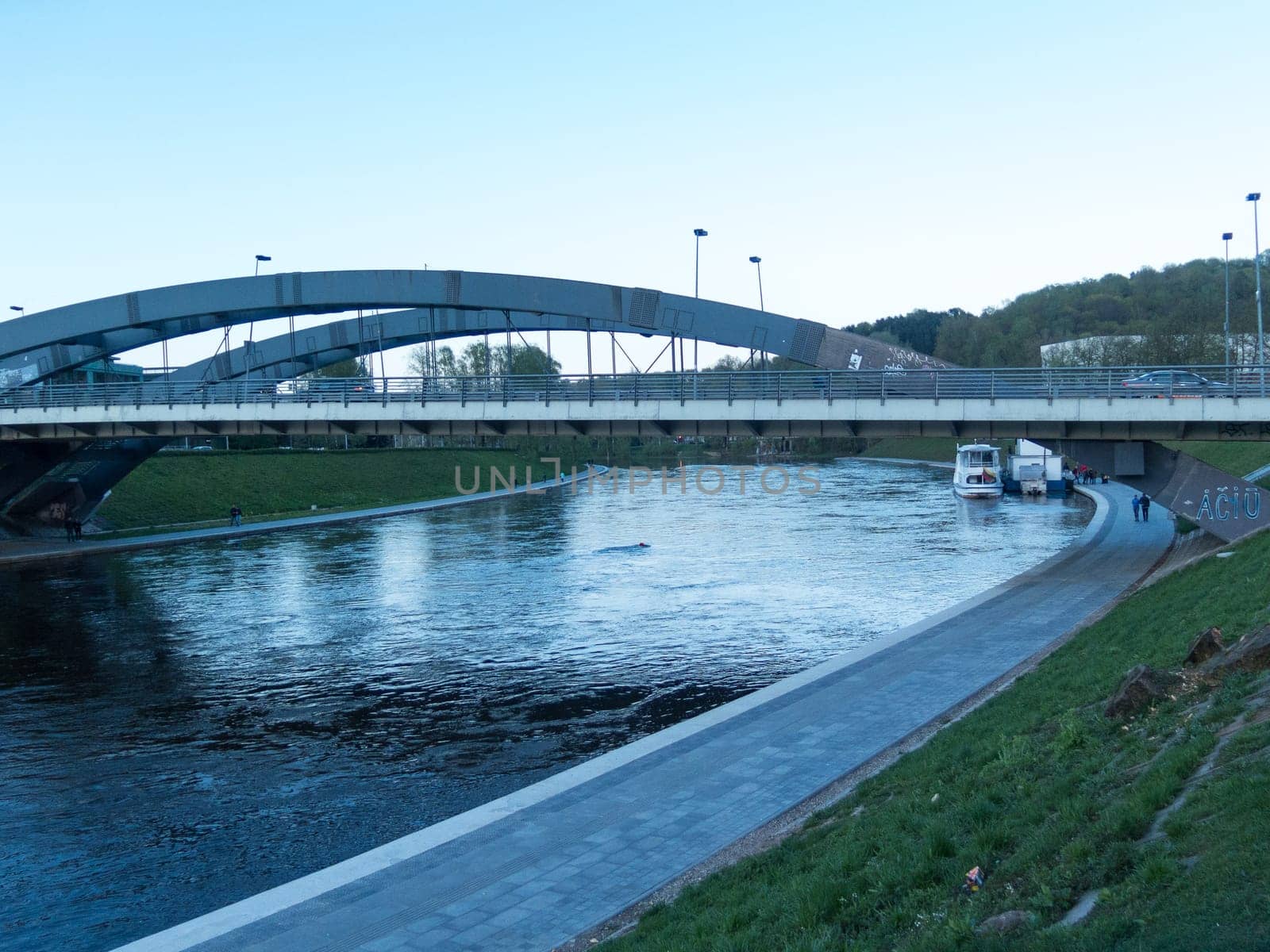 the river Neris is floating in the city of Vilnius under the bridge