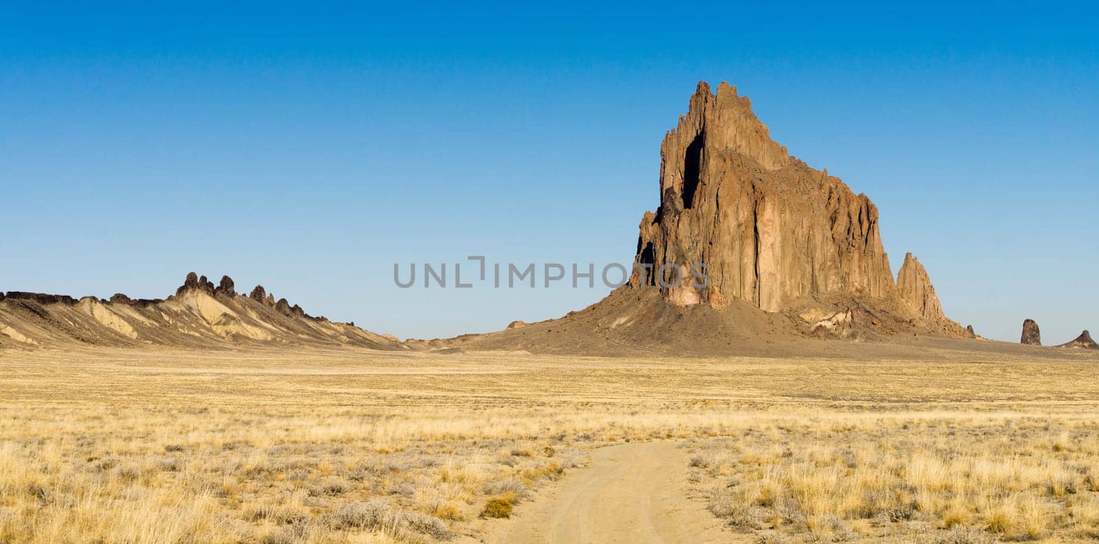 Blue skies appear in a panoramic view of Shiprock