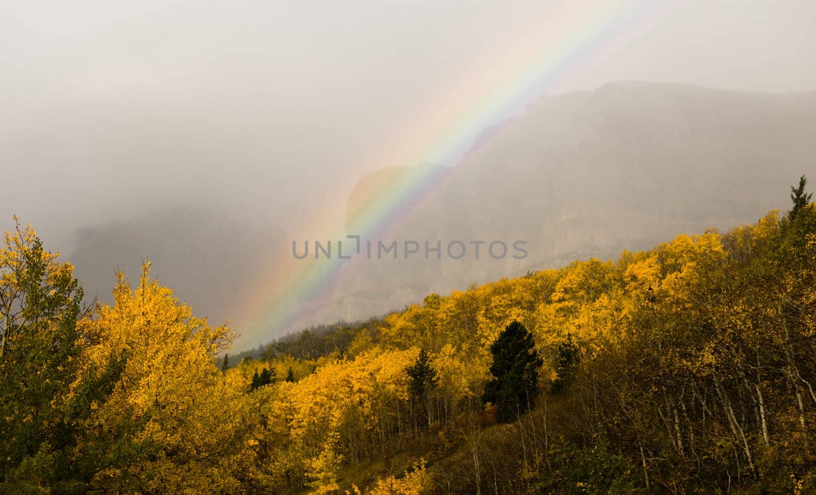 A storm passes over the east entrance of Glacier National Park creating a rainbow